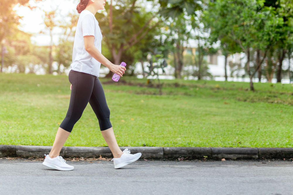 Woman,Walking,In,The,Park,With,Bottle,Water,In,Summer