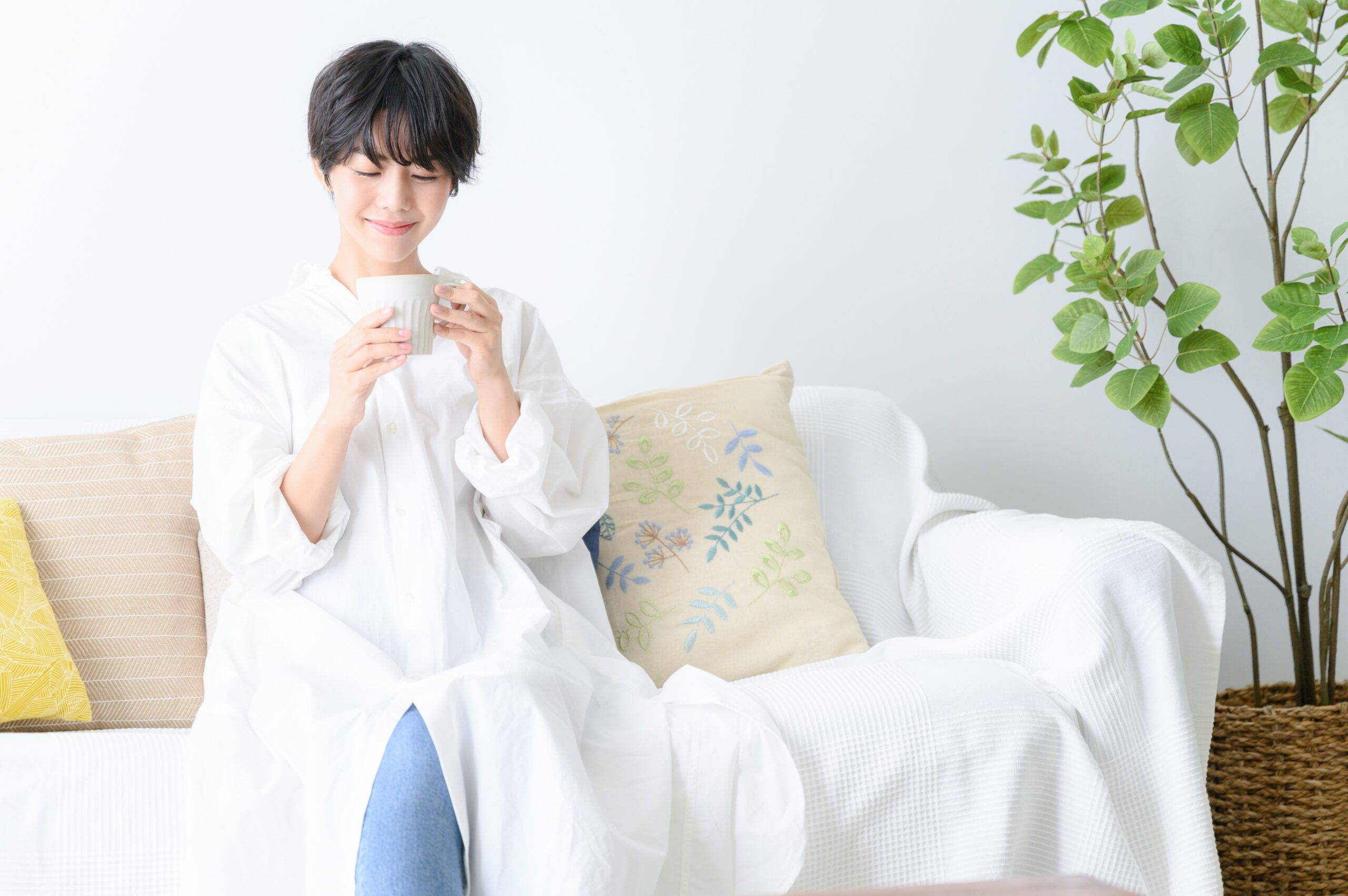 Woman,Relaxing,With,A,Cup,Of,Coffee,On,The,Sofa