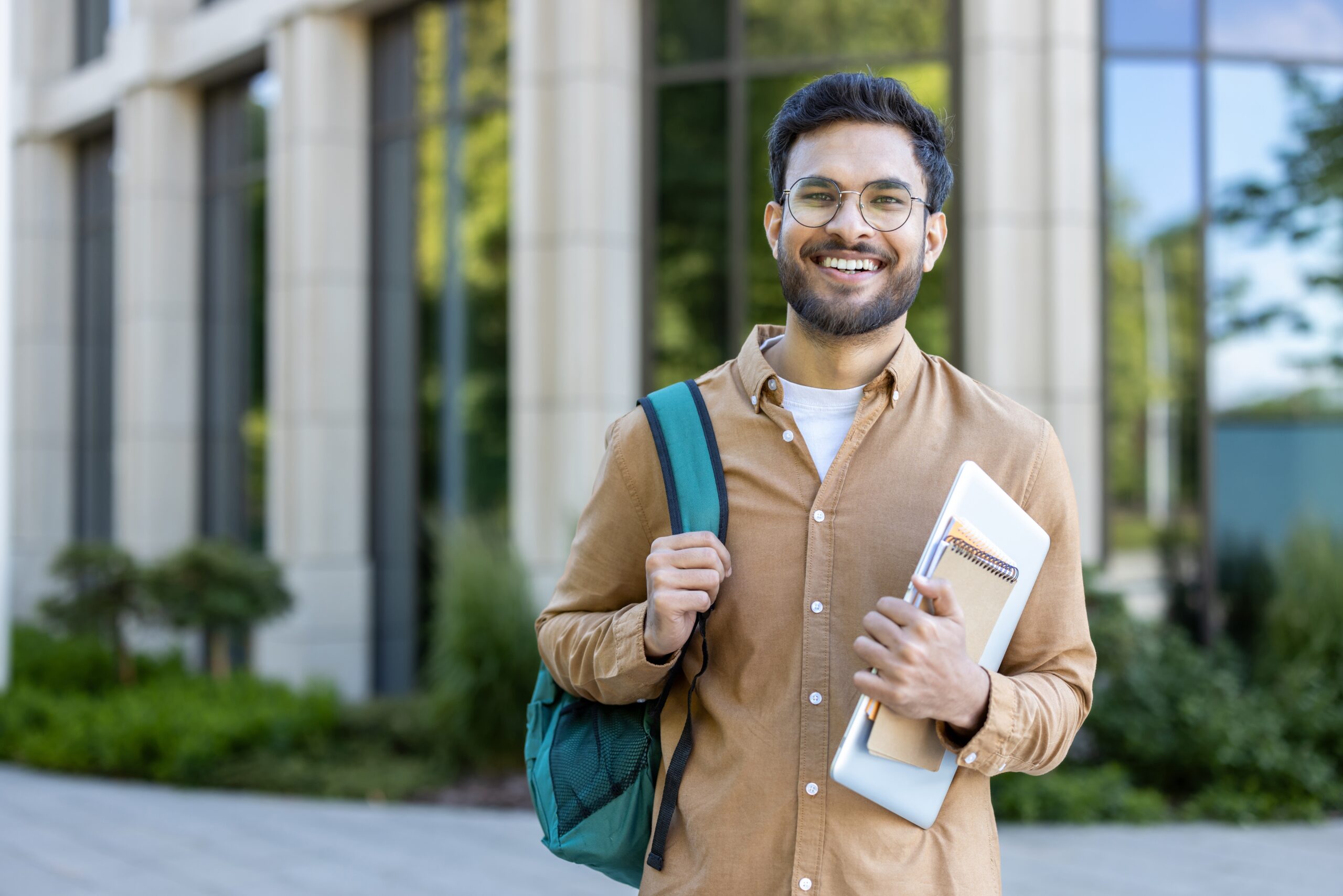 Smiling,Hispanic,Student,Stands,Outside,Academic,Building,Holding,Backpack,And