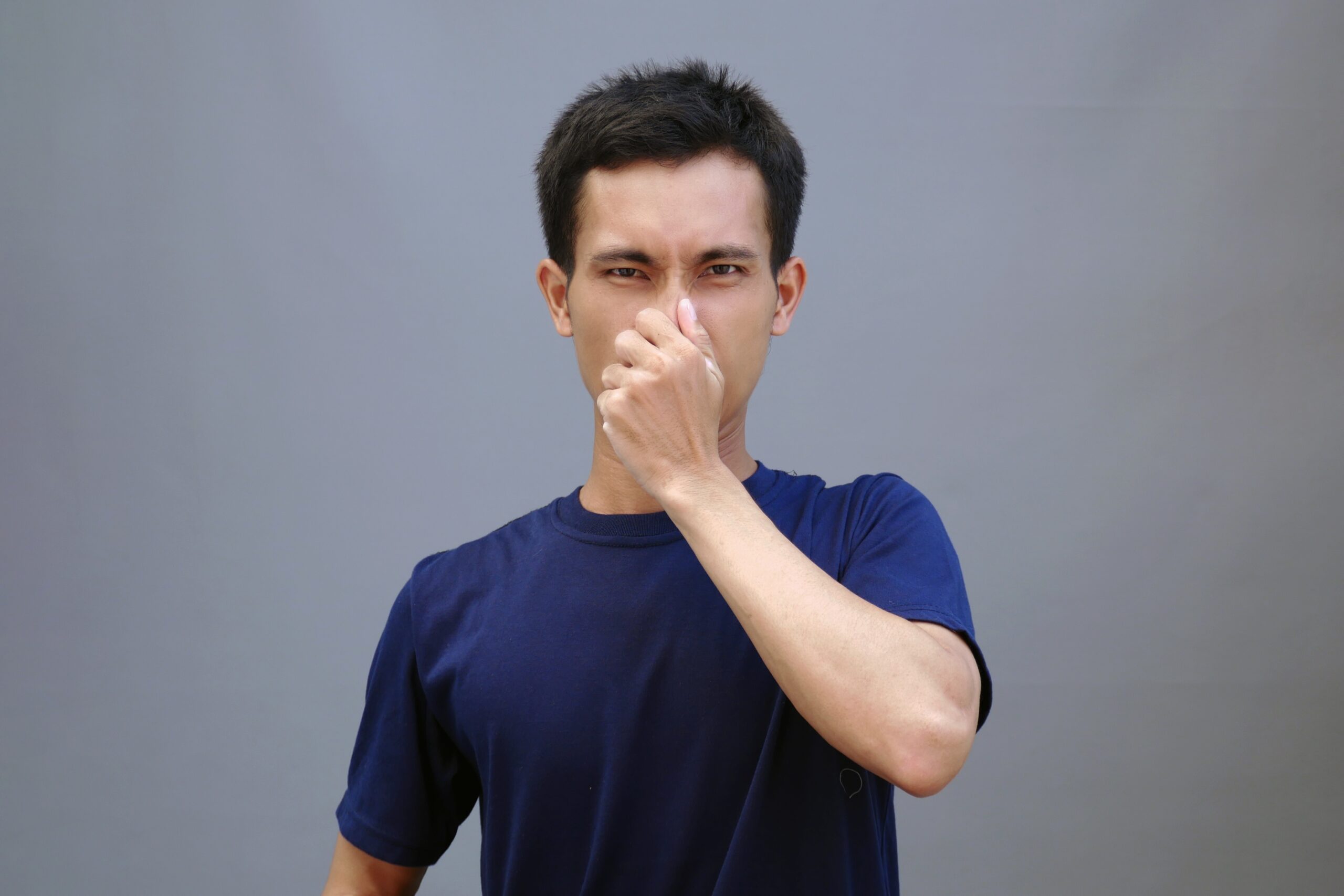 A,Handsome,Young,Asian,Man,Covering,His,Nose,Signals,A