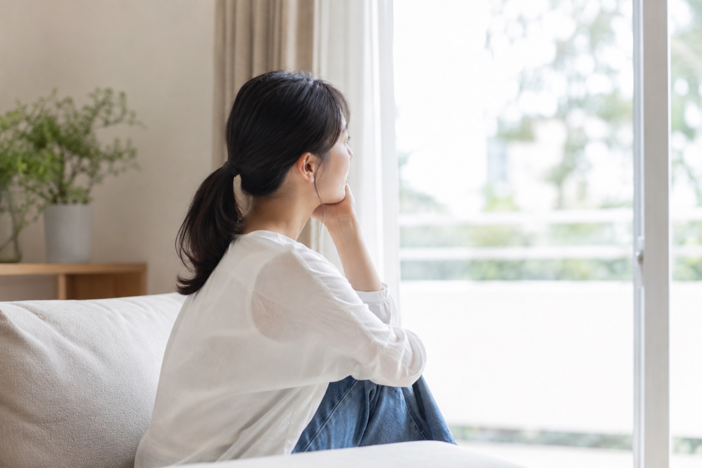 窓辺で物思いにふける女性の横顔