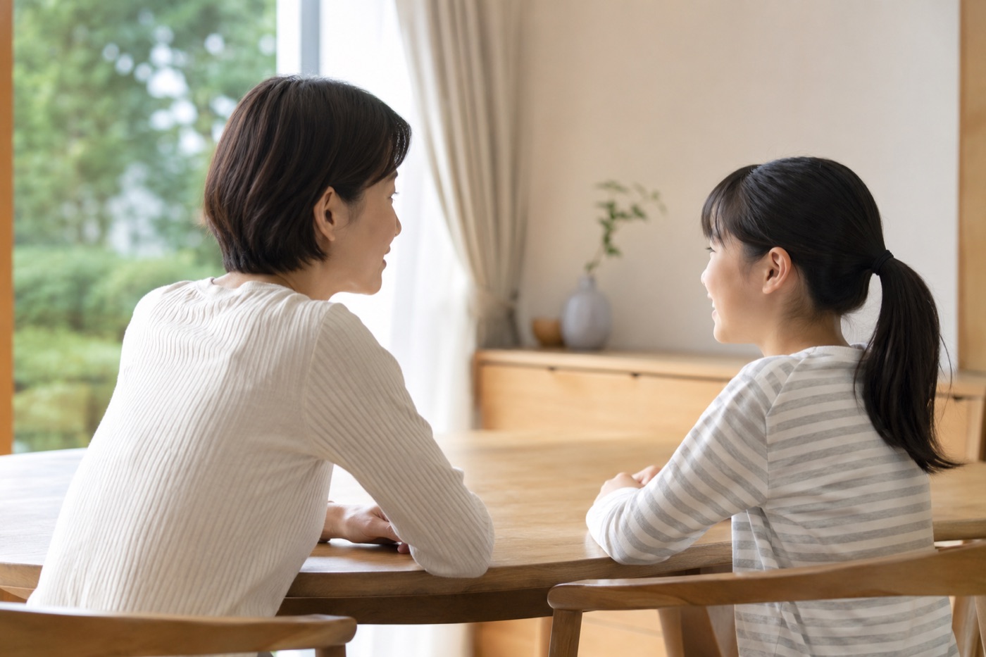 ダイニングテーブルで穏やかに会話する母娘